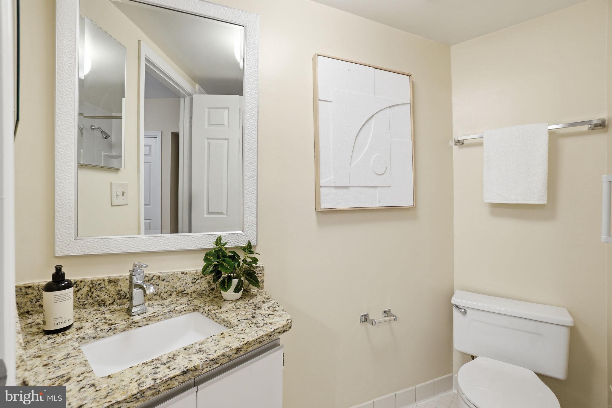 1835 16th Street Northwest, Unit 1 Washington, DC 20009 - Photo 16 of 27 a bathroom with a granite countertop sink a toilet and mirror