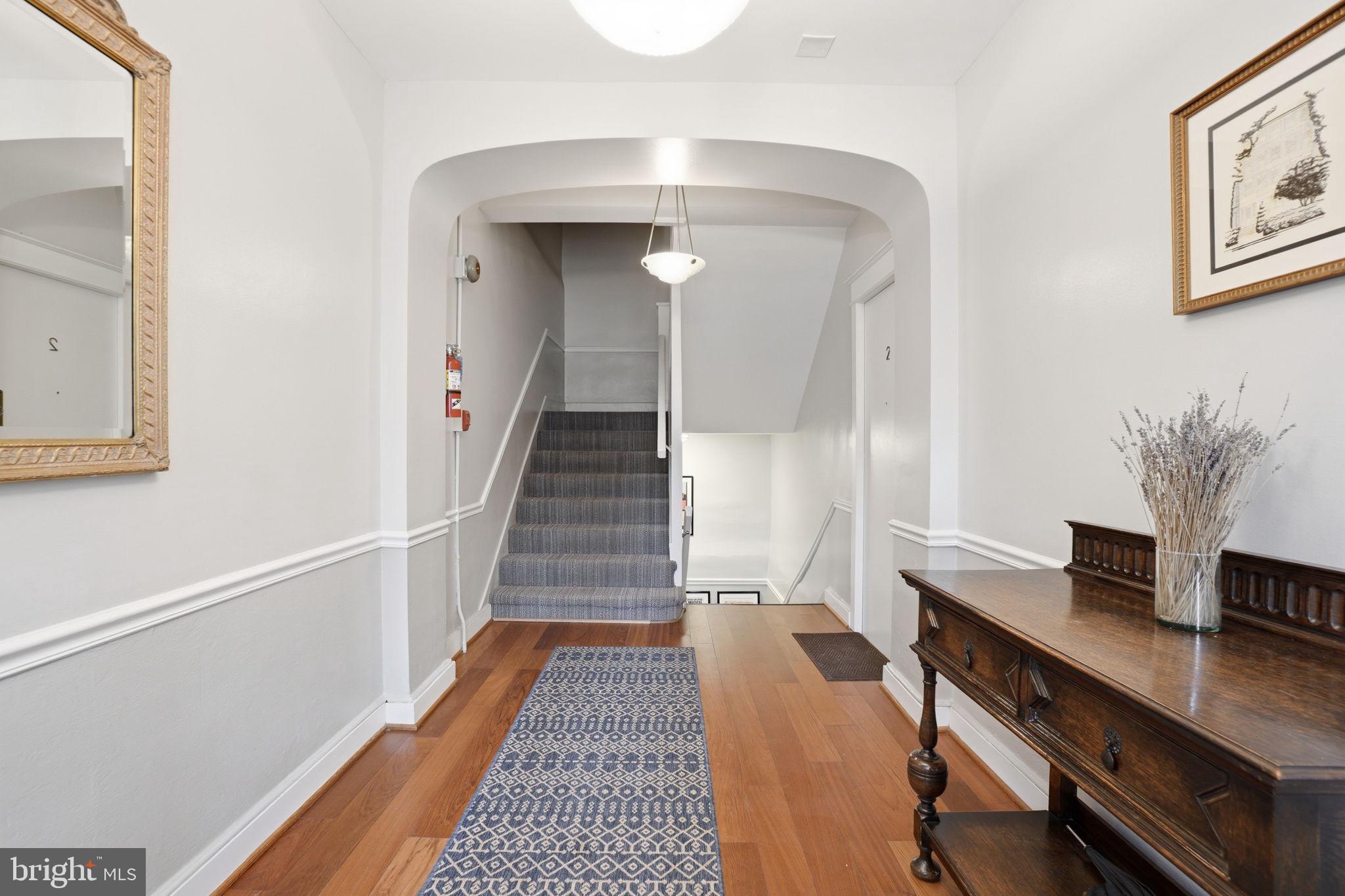1835 16th Street Northwest, Unit 1 Washington, DC 20009 - Photo 21 of 27 a view of a hallway to a livingroom with wooden floor and furniture