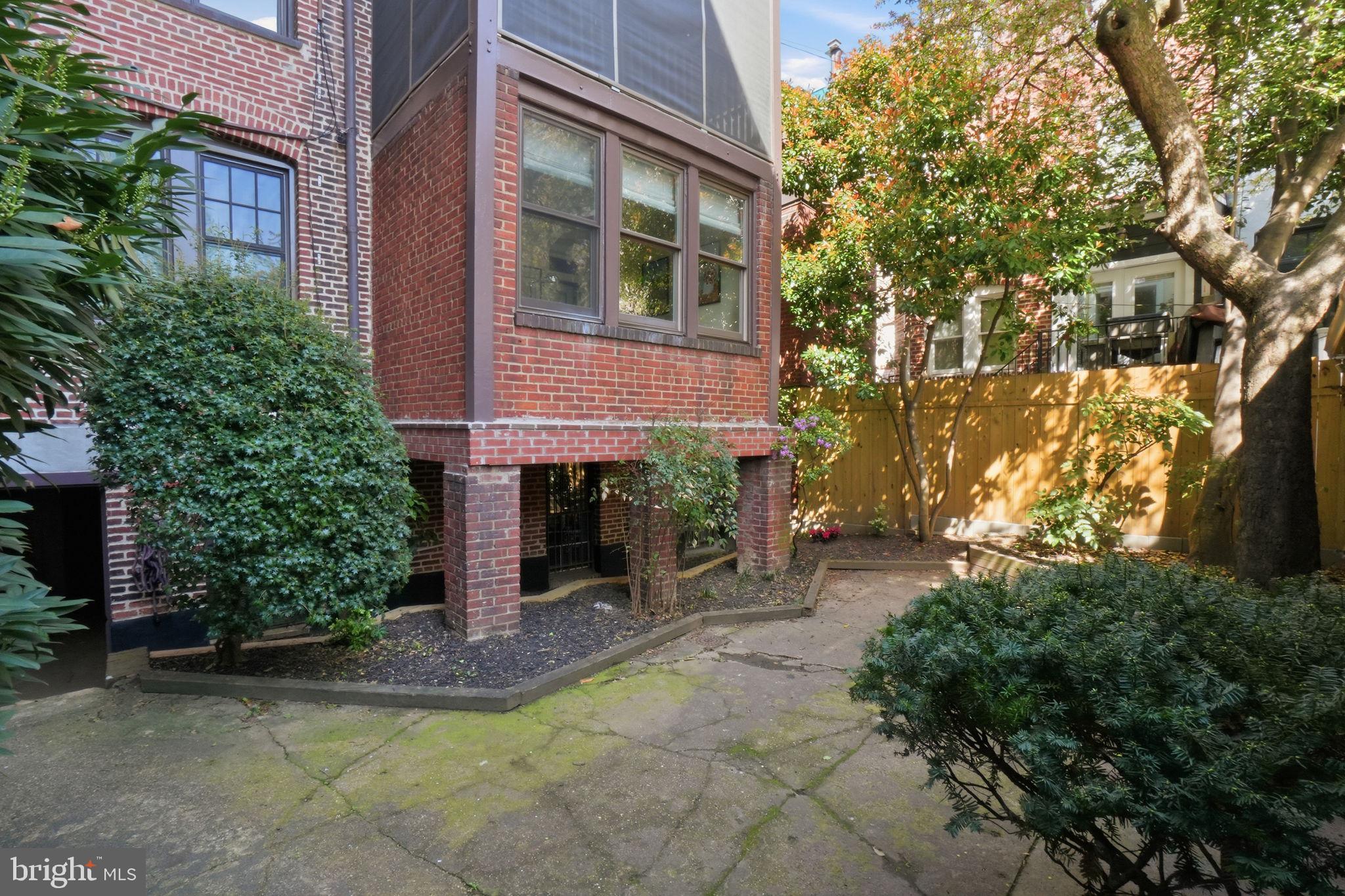 1835 16th Street Northwest, Unit 1 Washington, DC 20009 - Photo 26 of 27 a view of a brick house with a yard and large tree