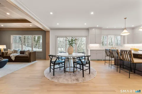a kitchen with a dining table chairs sink and cabinets