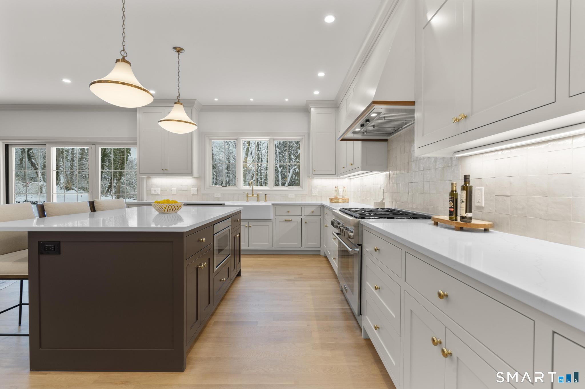 204 Glen Ridge Road Fairfield, CT 06825 - Photo 19 of 45 a large kitchen with a large counter top a sink a window and stainless steel appliances