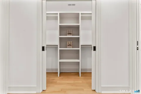 a bathroom with a granite countertop sink a mirror a potted plant and shower