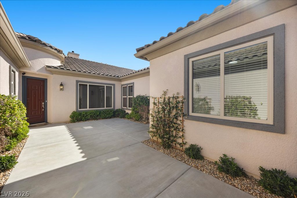 2125 De Rouge Avenue Henderson, NV 89044 - Photo 30 of 96 A welcoming front entry features a richly toned door and pristine concrete pathways leading into the residence.