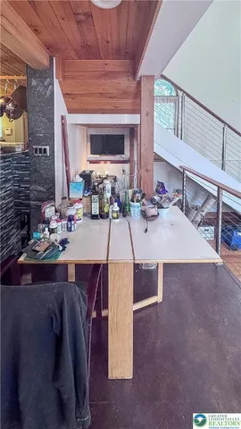 a living room with stainless steel appliances kitchen island granite countertop furniture a rug and a window