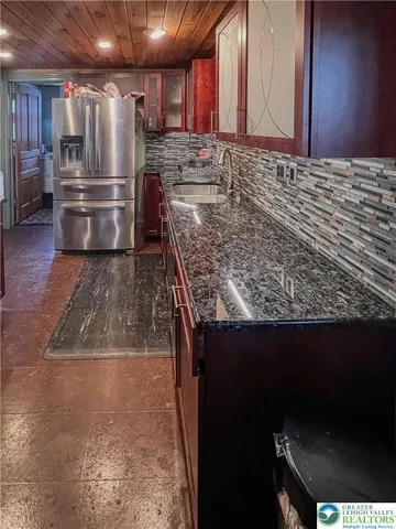 a kitchen with kitchen island granite countertop a sink stainless steel appliances and cabinets