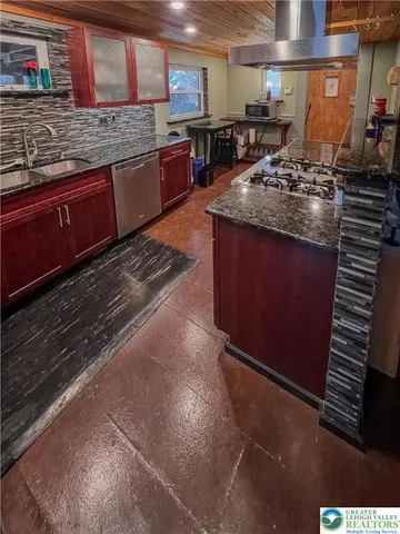 a kitchen with stainless steel appliances granite countertop a stove a sink and a microwave