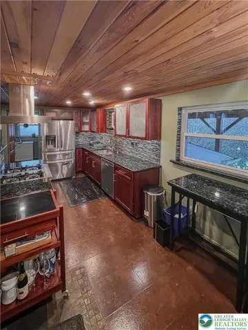a open kitchen with stainless steel appliances granite countertop a stove and a sink
