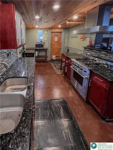 a kitchen with stainless steel appliances granite countertop a stove a sink and a microwave