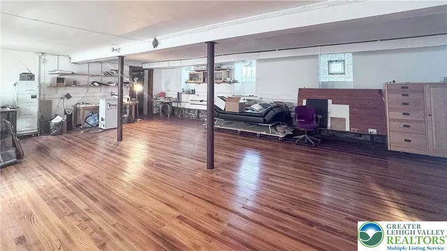 a living room with furniture gym equipment and wooden floor