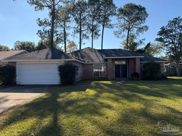 a view of a house with a yard and a large tree