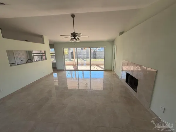 a view of an empty room with a fireplace and a window