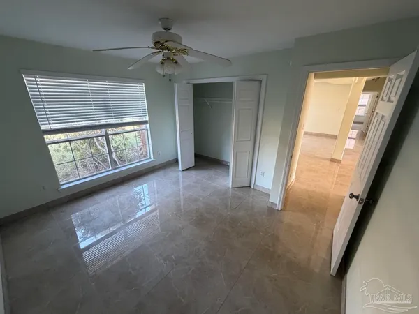 an empty room with windows and chandelier