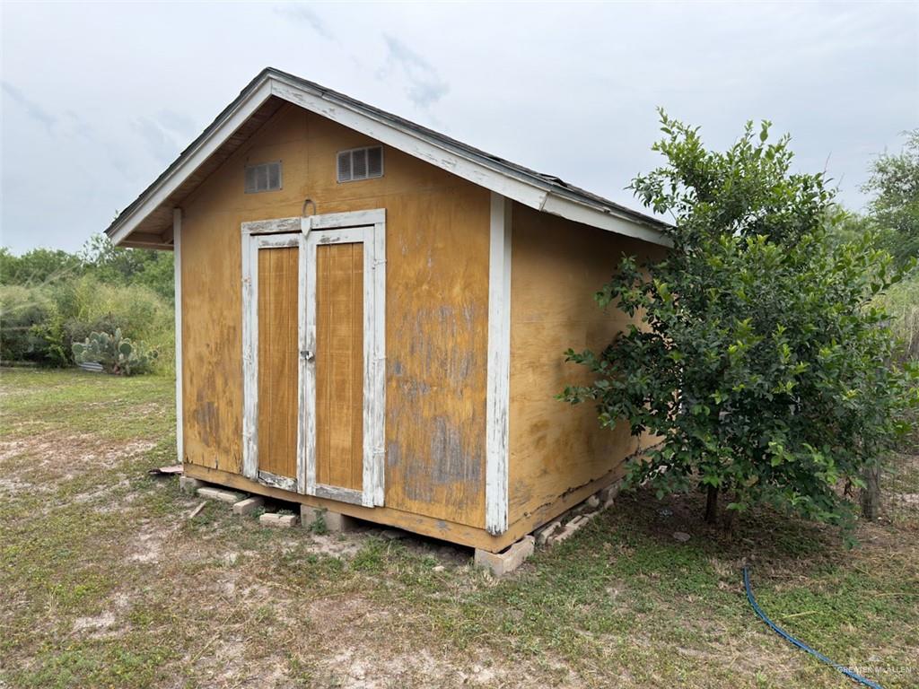 7435 Dillon Road Donna, TX 78537 - Photo 11 of 17 Freestanding storage shed featuring a gabled roof, dual entry doors, and upper transom windows