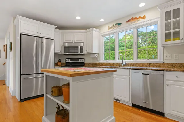 a view of a kitchen with stainless steel appliances granite countertop a stove and a sink