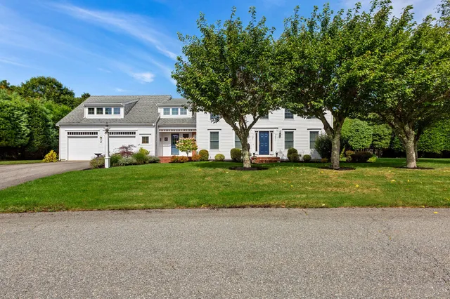 a front view of a house with a yard and trees