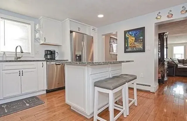 a kitchen with granite countertop a sink cabinets and wooden floor