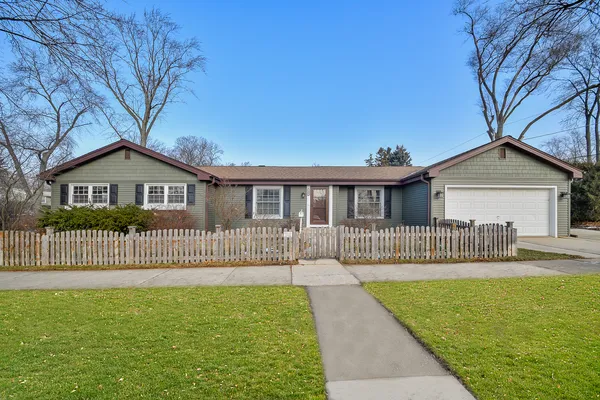 a front view of a house with a garden and yard