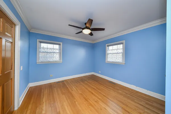 a view of a big room with wooden floor and a chandelier fan