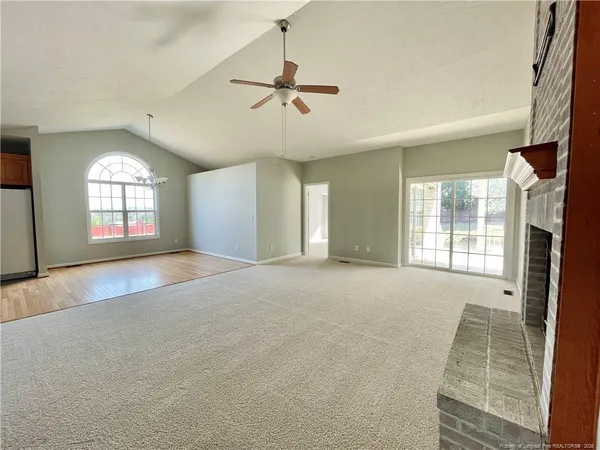 a view of a livingroom with a chandelier fan and windows