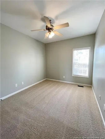 an empty room with a window and a ceiling fan