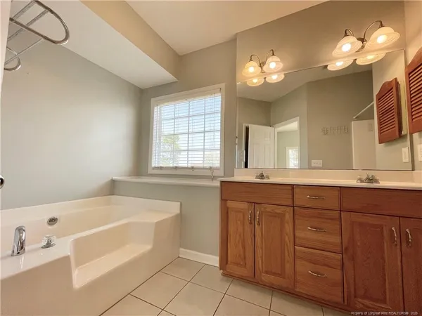 a spacious bathroom with a mirror sink and shower