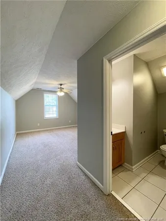 an empty room with windows and chandelier fan