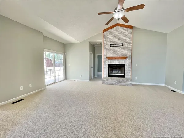 en empty room with a fireplace and windows