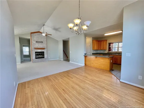 a view of an empty room with a fireplace and a window