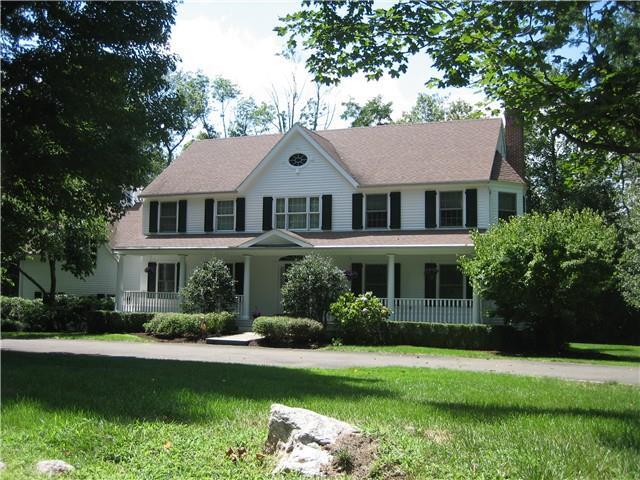 390 Hunting Ridge Road Stamford, CT 06903 - Photo 1 of 1 a front view of a house with garden and trees