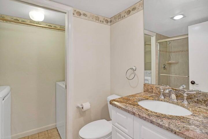 3134 Southwest 20th Terrace, Unit 11D Delray Beach, FL 33445 - Photo 7 of 14 a bathroom with a granite countertop sink toilet and shower