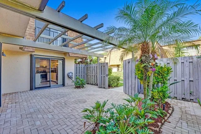 a view of a house with a yard and potted plants