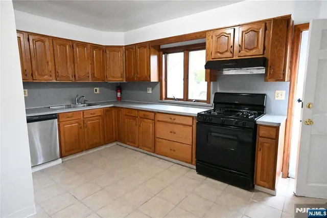 a view of an empty room with windows and a fireplace