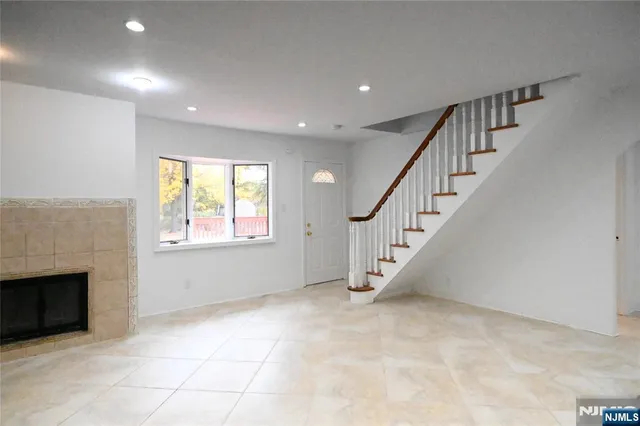 a view of an empty room with a fireplace and a window
