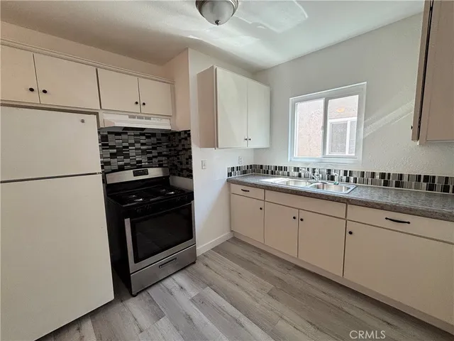 a kitchen with granite countertop white cabinets and black appliances