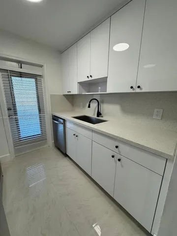 a kitchen with cabinets appliances and a sink