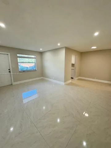 an empty room with windows and ceiling fan