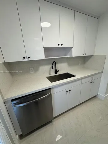 a kitchen with cabinets appliances and a sink