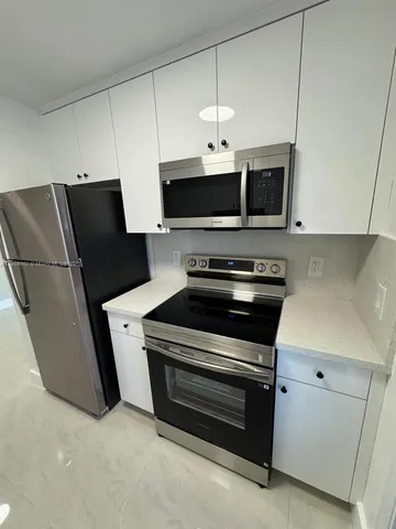 a kitchen with stainless steel appliances a stove microwave and refrigerator