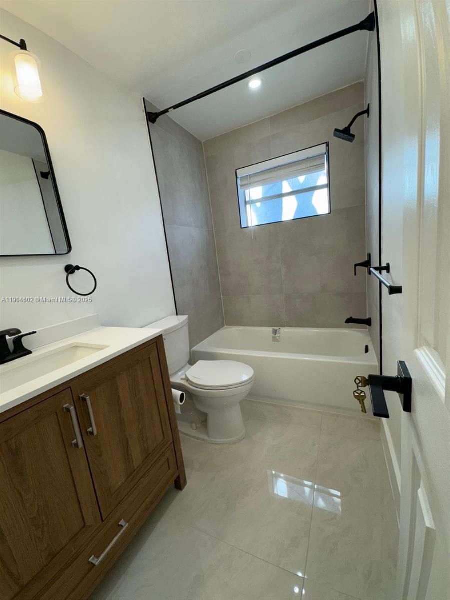 2418 Polk Street, Unit 104 Hollywood, FL 33020 - Photo 10 of 16 a spacious bathroom with a sink a toilet and a bathtub