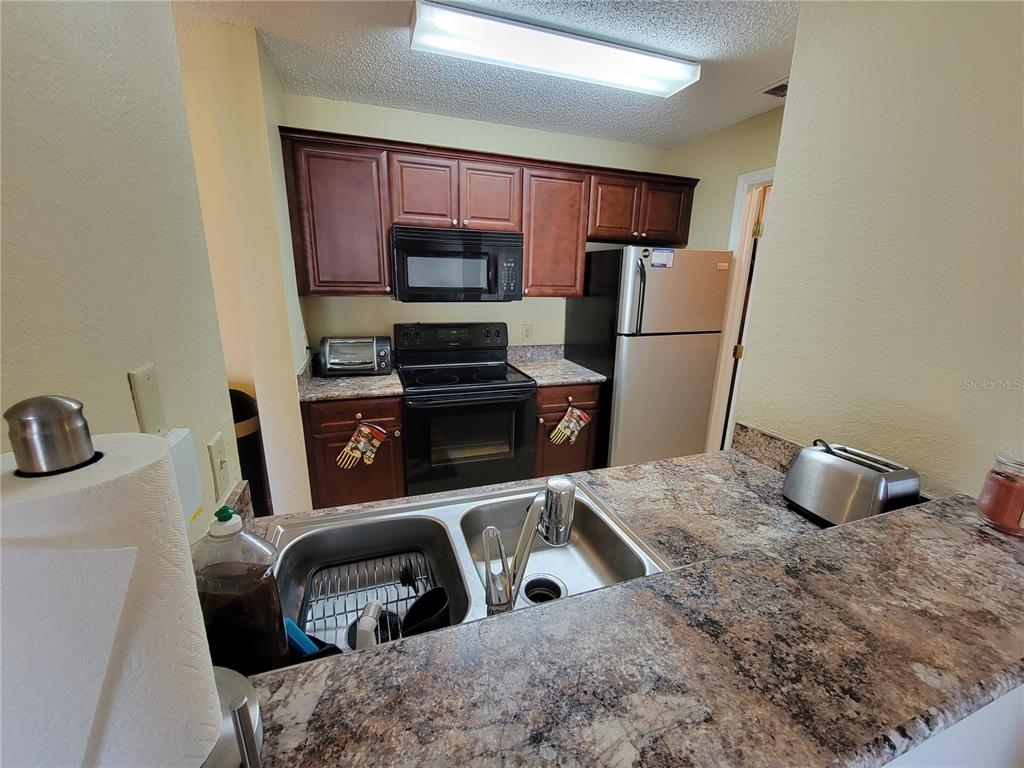 3705 Southwest 27th Street, Unit 1016 Gainesville, FL 32608 - Photo 11 of 31 a kitchen with a sink a stove and refrigerator