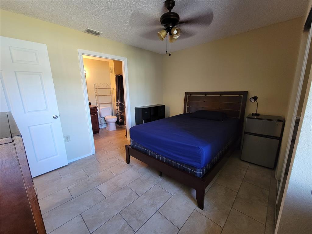 3705 Southwest 27th Street, Unit 1016 Gainesville, FL 32608 - Photo 14 of 31 a bedroom with a bed and a table in it