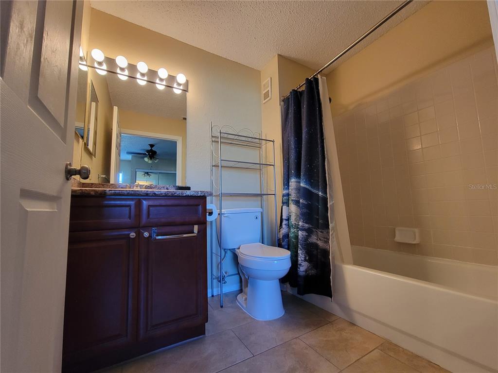3705 Southwest 27th Street, Unit 1016 Gainesville, FL 32608 - Photo 16 of 31 a bathroom with a granite countertop sink toilet and shower