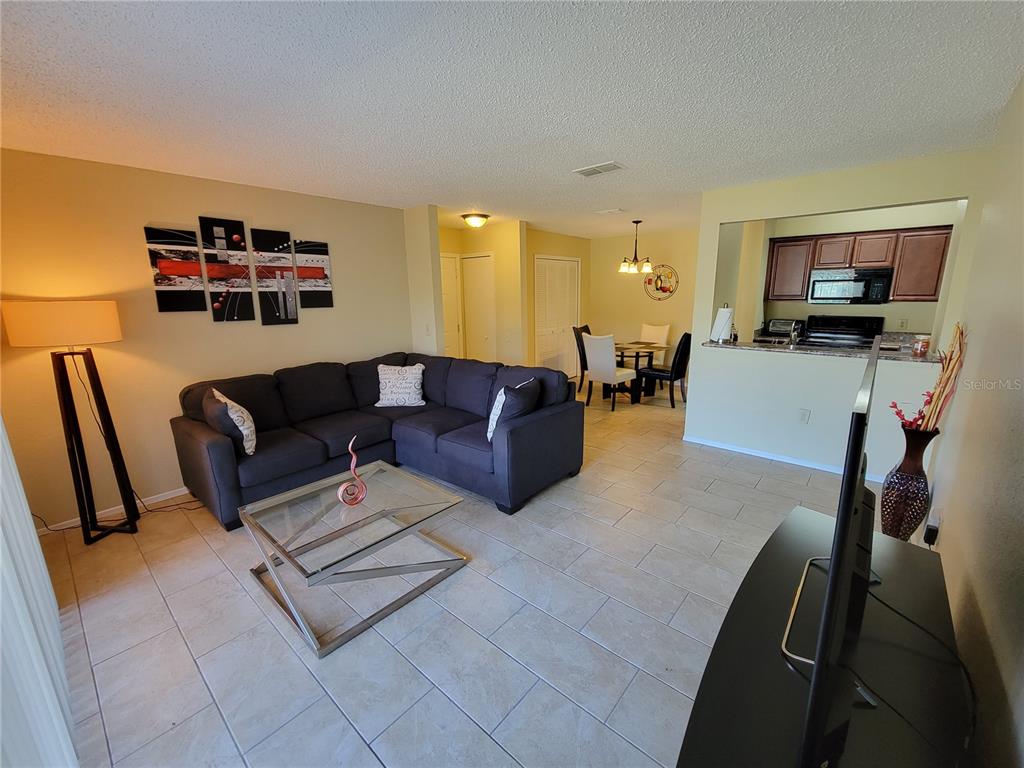 3705 Southwest 27th Street, Unit 1016 Gainesville, FL 32608 - Photo 4 of 31 a living room with furniture and a flat screen tv