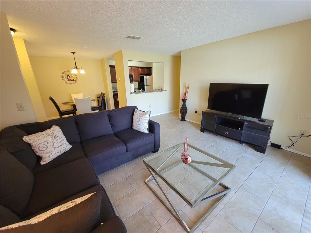 3705 Southwest 27th Street, Unit 1016 Gainesville, FL 32608 - Photo 5 of 31 a living room with furniture and a flat screen tv