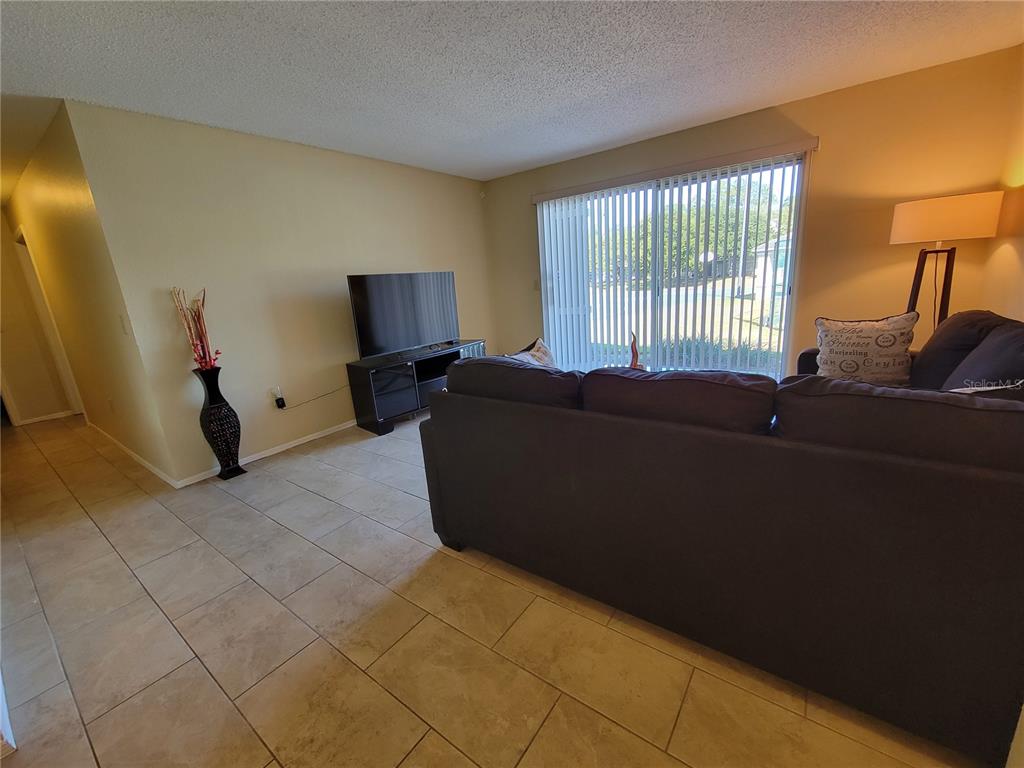 3705 Southwest 27th Street, Unit 1016 Gainesville, FL 32608 - Photo 7 of 31 a living room with furniture and a flat screen tv