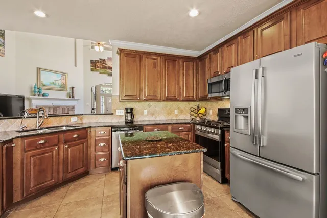 a kitchen with stainless steel appliances granite countertop a sink stove and cabinets