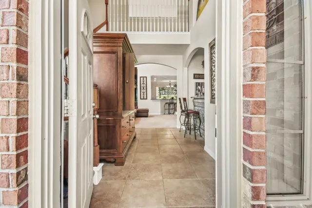 a view of a hallway with wooden floor and windows