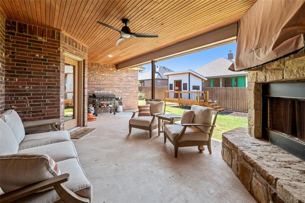 3801 Kady Ridge Abilene, TX 79606 - Photo 37 of 40 Covered patio featuring a wood-paneled ceiling, ceiling fan, and stone-clad fireplace