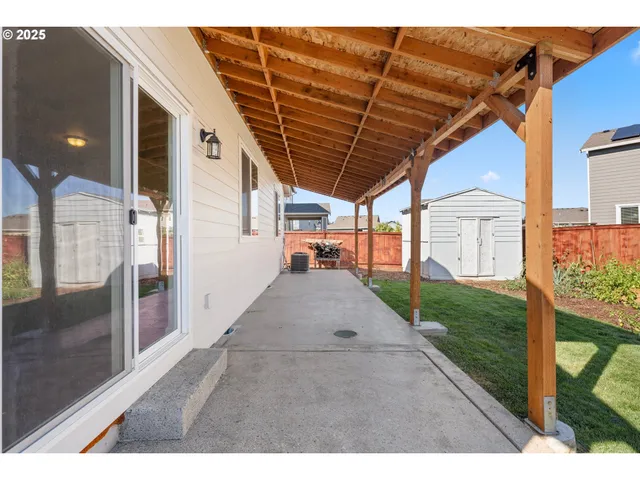 a view of a backyard with plants and brick wall