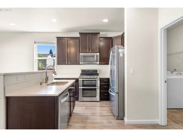 a kitchen with kitchen island a counter top space stainless steel appliances and cabinets